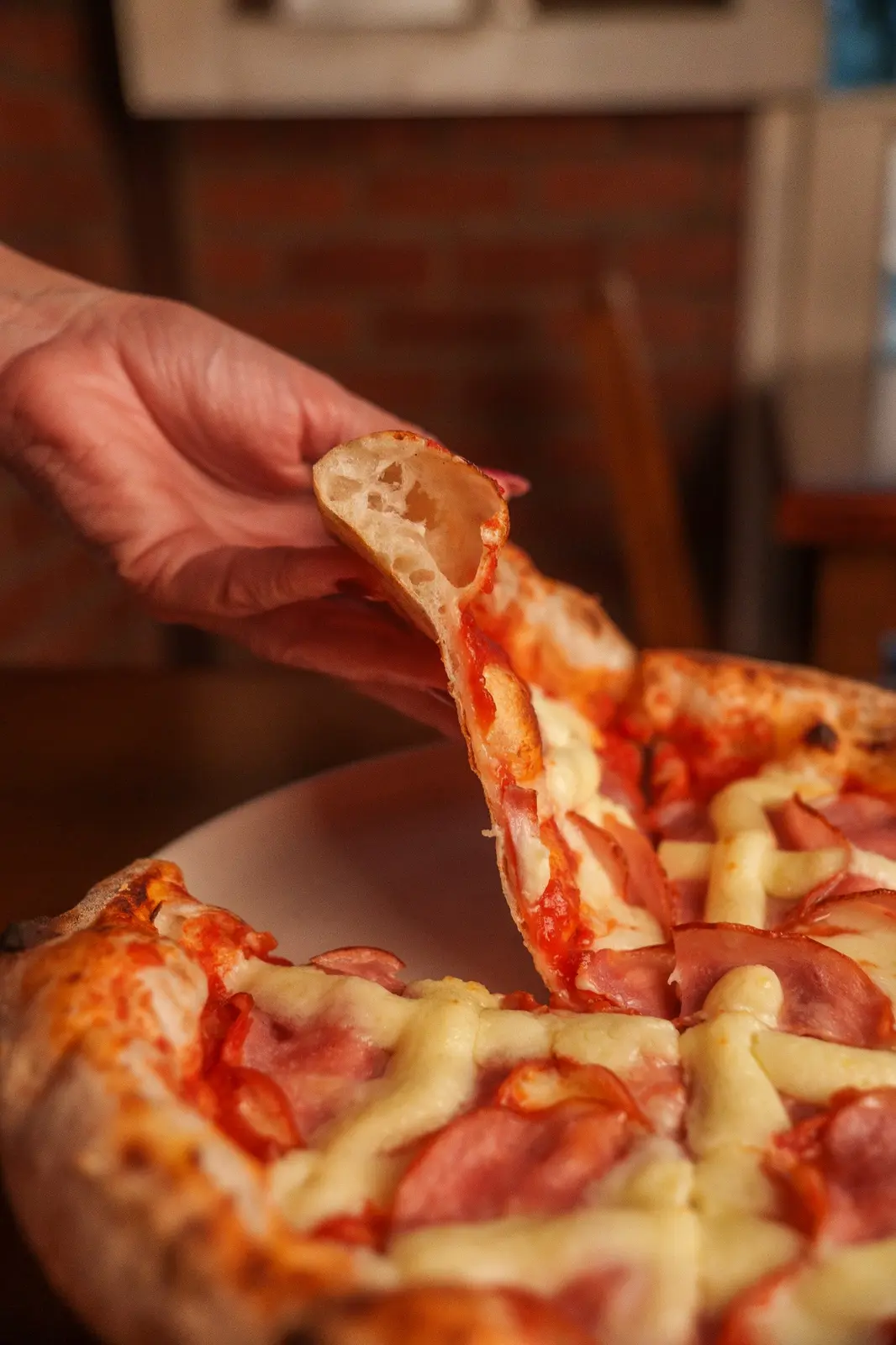 Fatia de pizza artesanal da Fiume Nero sendo servida